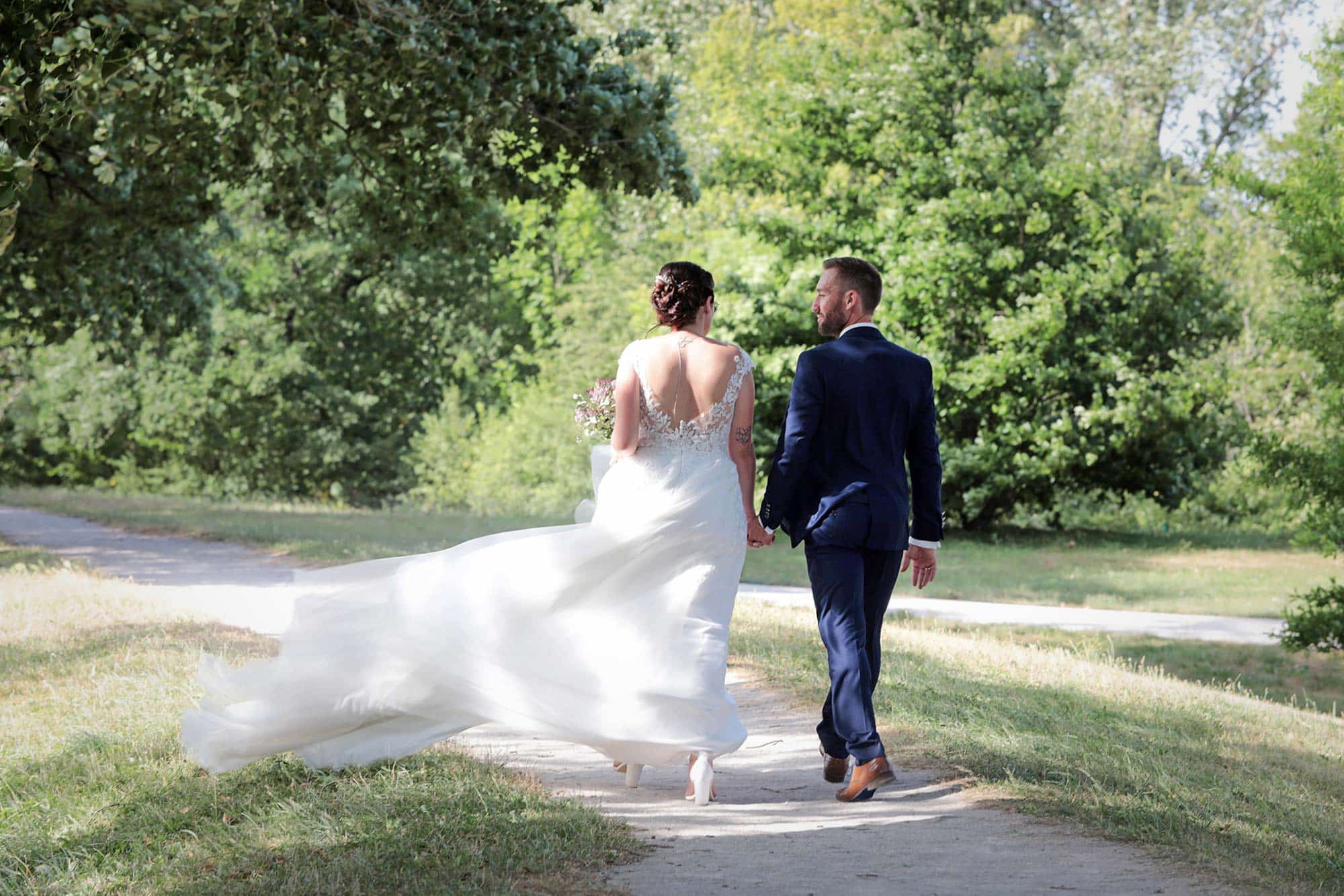 Les mariés avancent dans un chemin pendant que je les photographie
