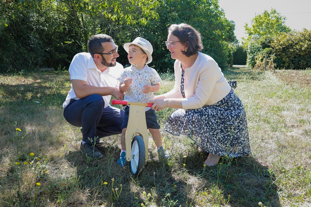 Reportage photo, parents leur enfant dans le jardin pour la fête du baptême