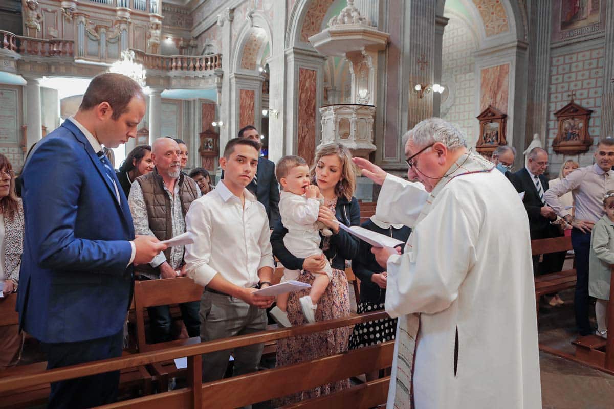 la prêtre bénit un bébé, cérémonie du baptême à l'église